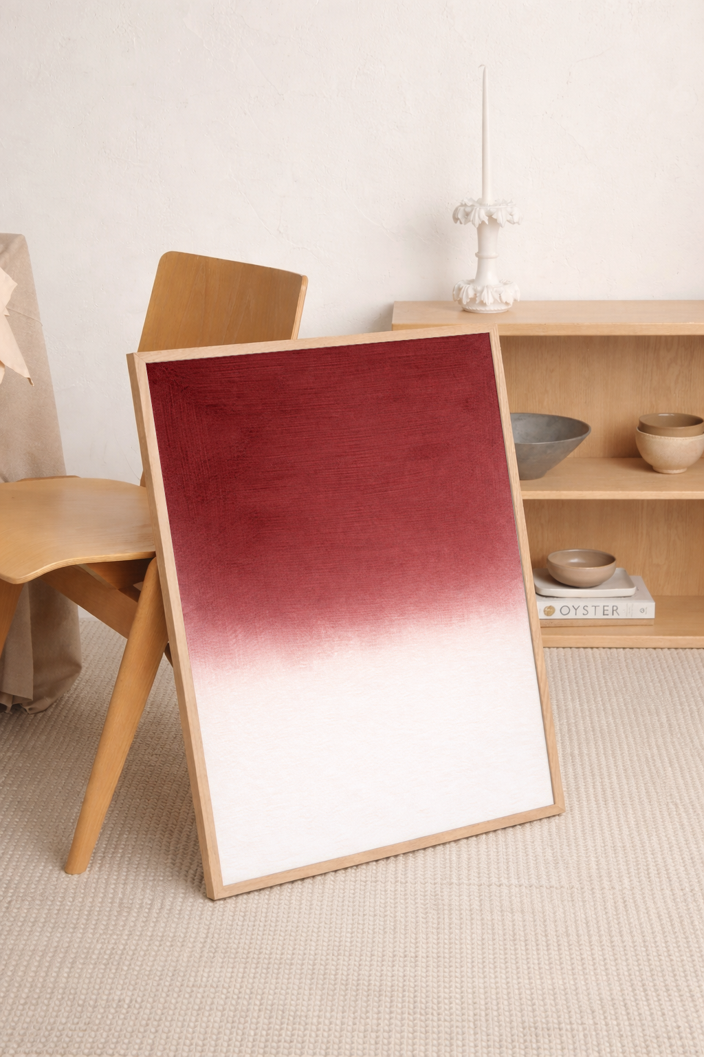 Red gradient painting on a wooden easel in a minimalistic room.