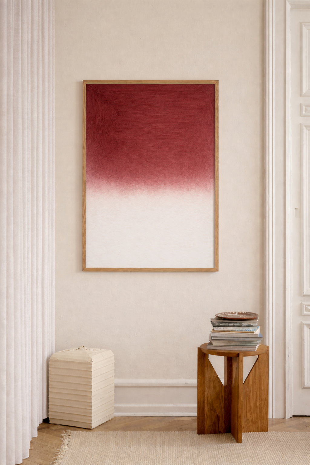 Framed abstract art piece on a wall with a wooden side table and stool below.